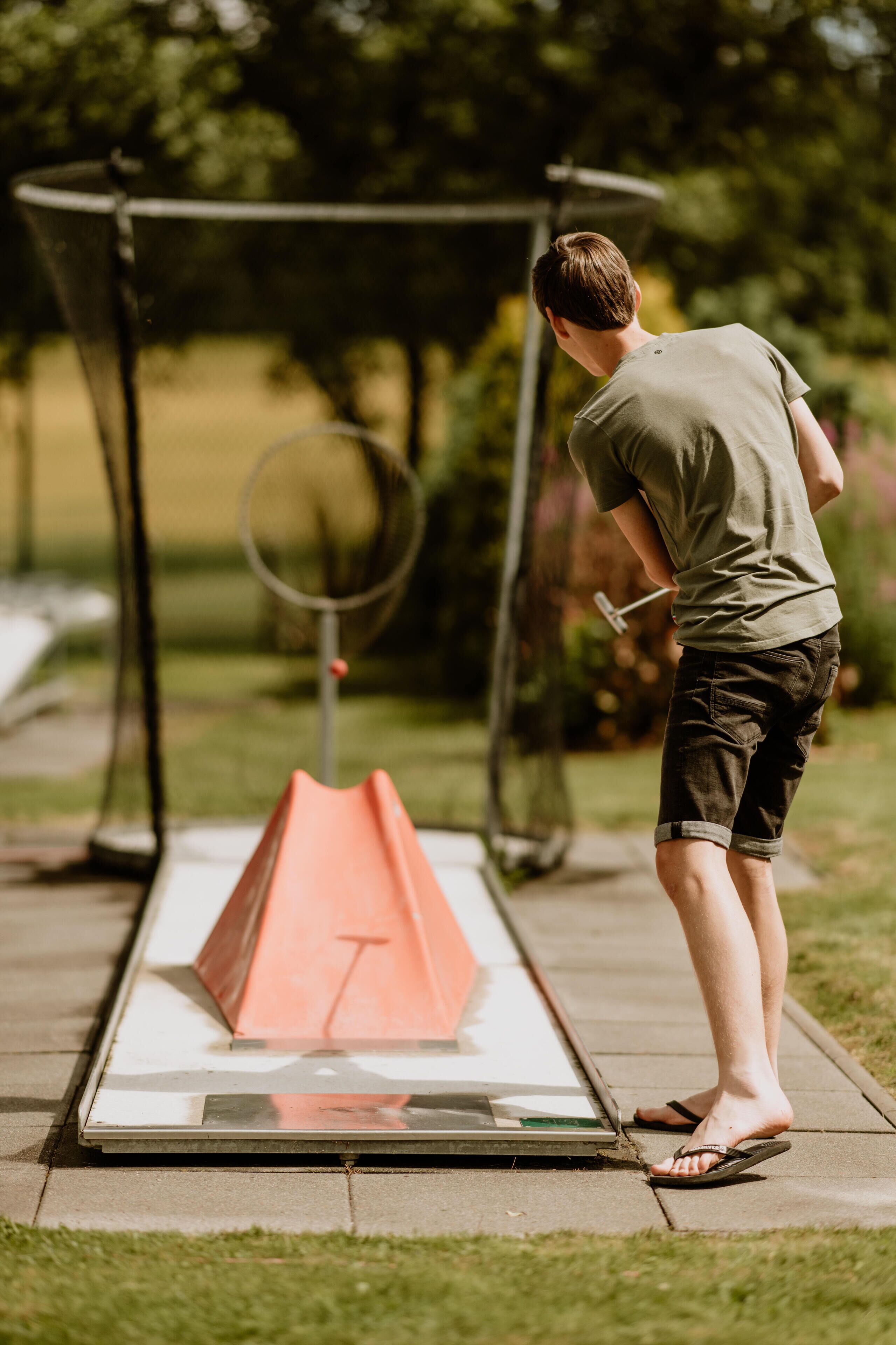 A person standing on a platform with a netted enclosure, possibly for an outdoor activity.