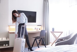 Habitación de hotel con cama, escritorio, televisión y silla.