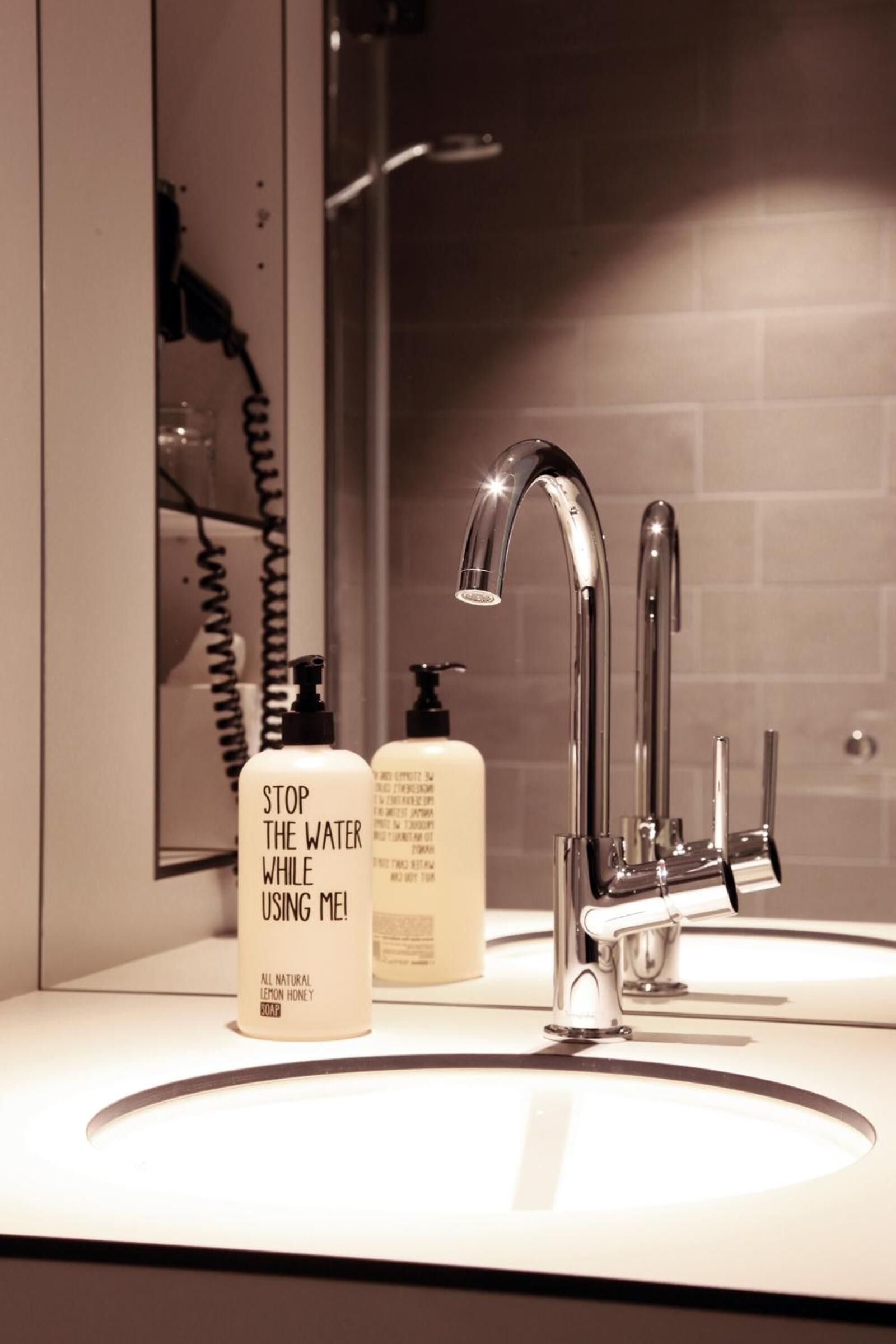 A bathroom with a modern sink, a mirror, and a shower.