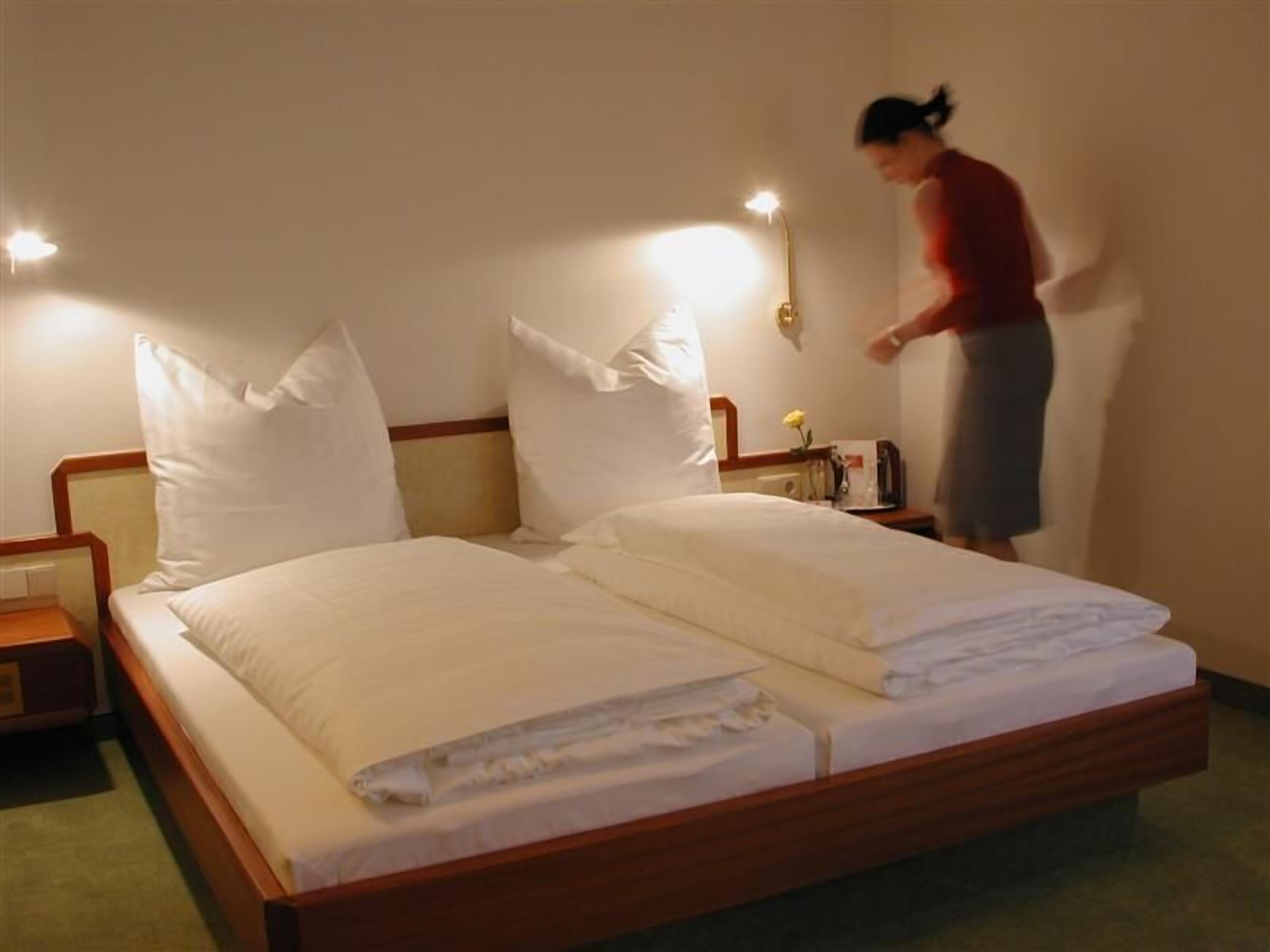 Ein Hotelzimmer mit einem Doppelbett, zwei Nachttischen und einem Beistelltisch.