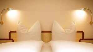 A neatly made bed with white linens and two bedside lamps on either side. - Hotel Stadt Balingen (Balingen)