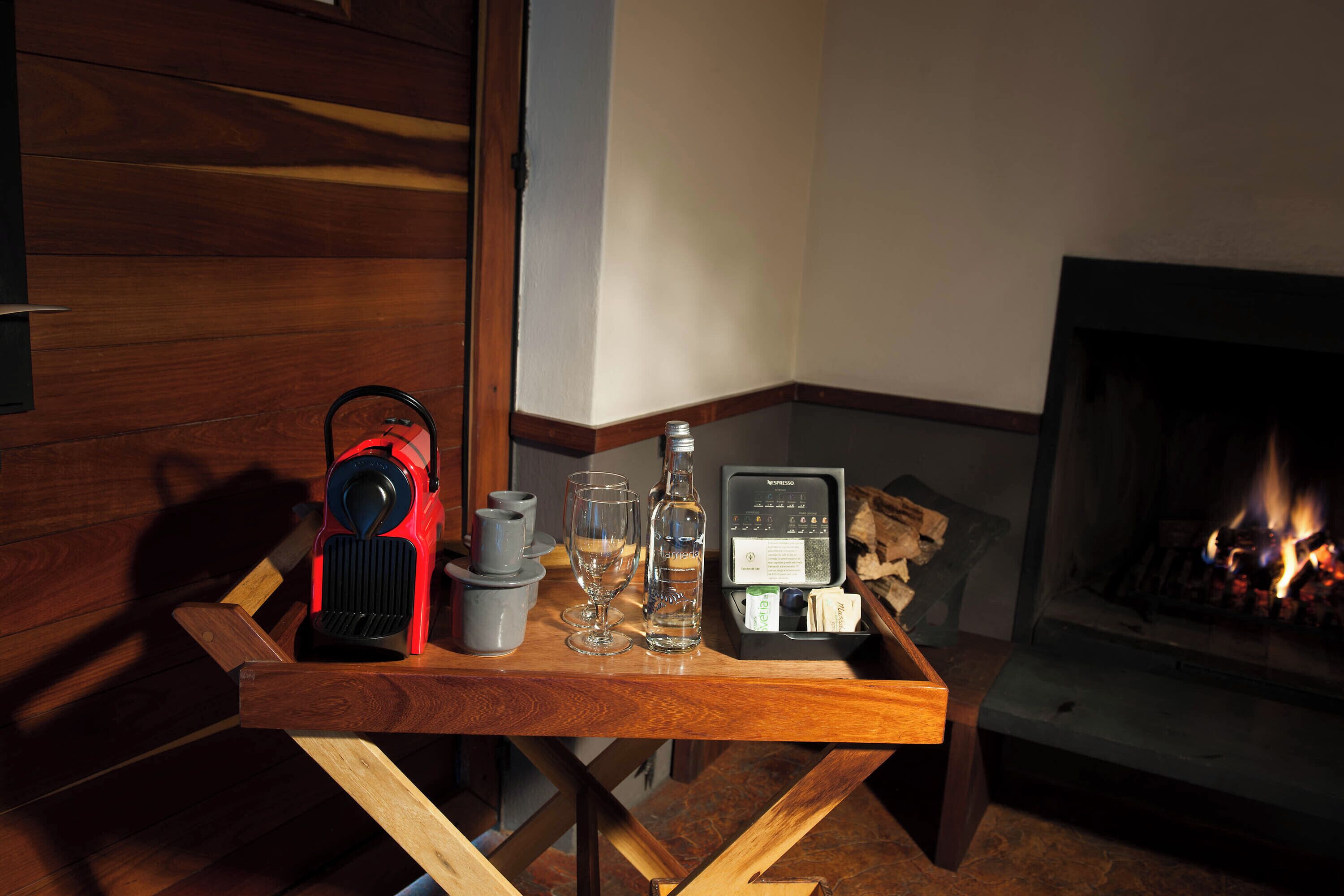 Ein Holztisch mit einem Transportheizer, Gläsern, einer Flasche und einer Tablett mit Taschentüchern.
