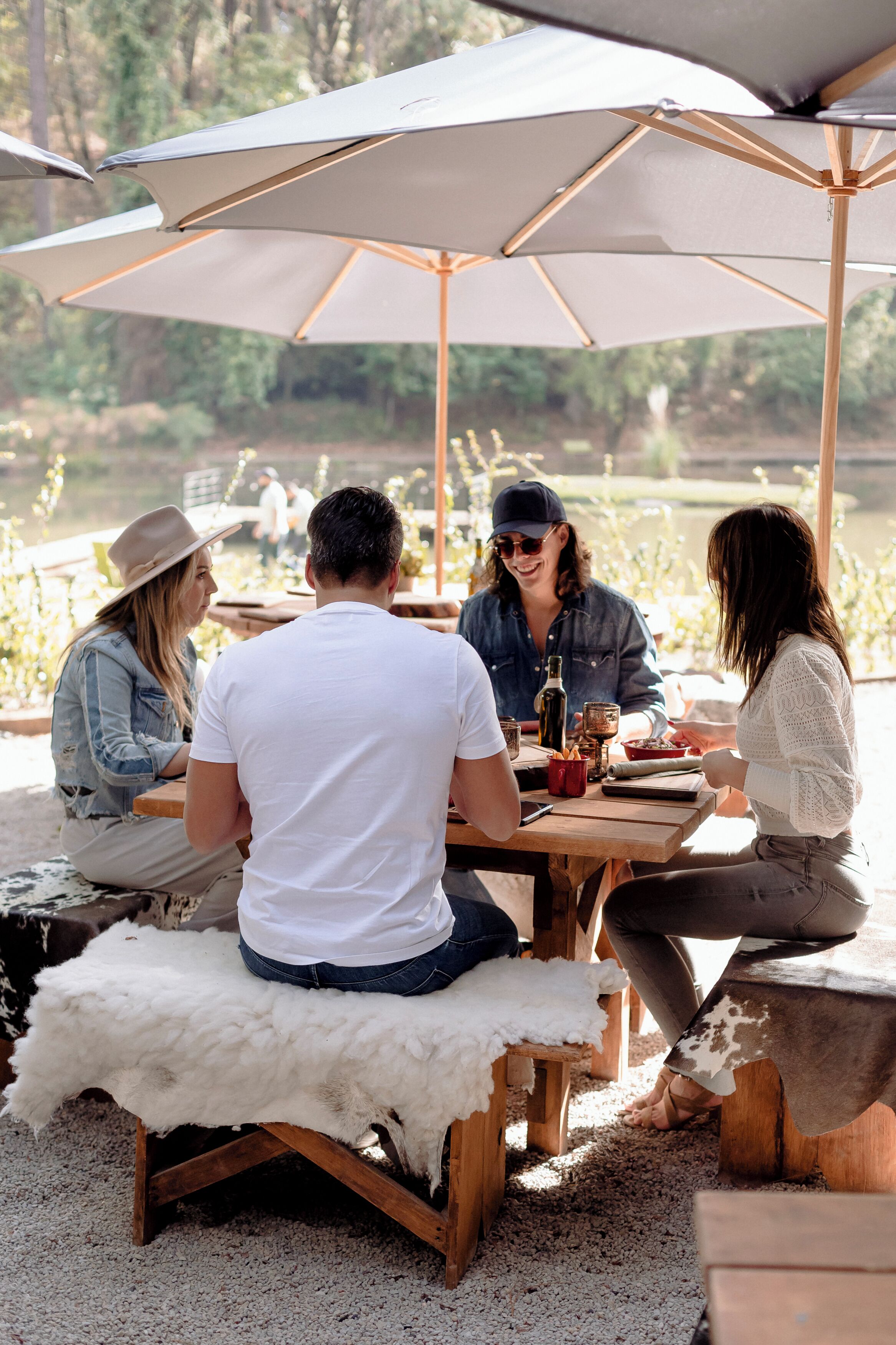 A group of people dining outdoors under a large umbrella.
