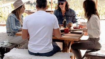 A group of people dining outdoors under a large umbrella.
