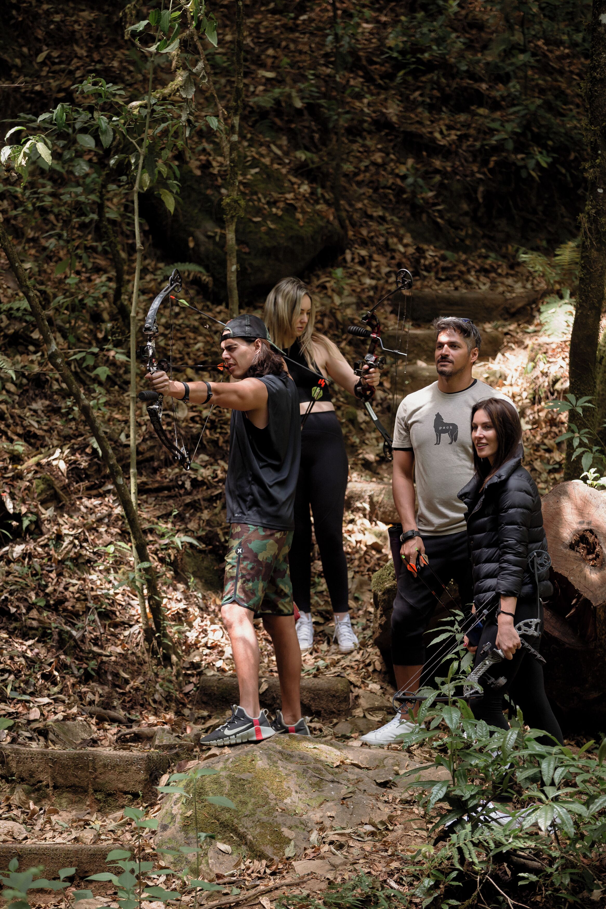A group of people in a forested area with a stone pathway.
