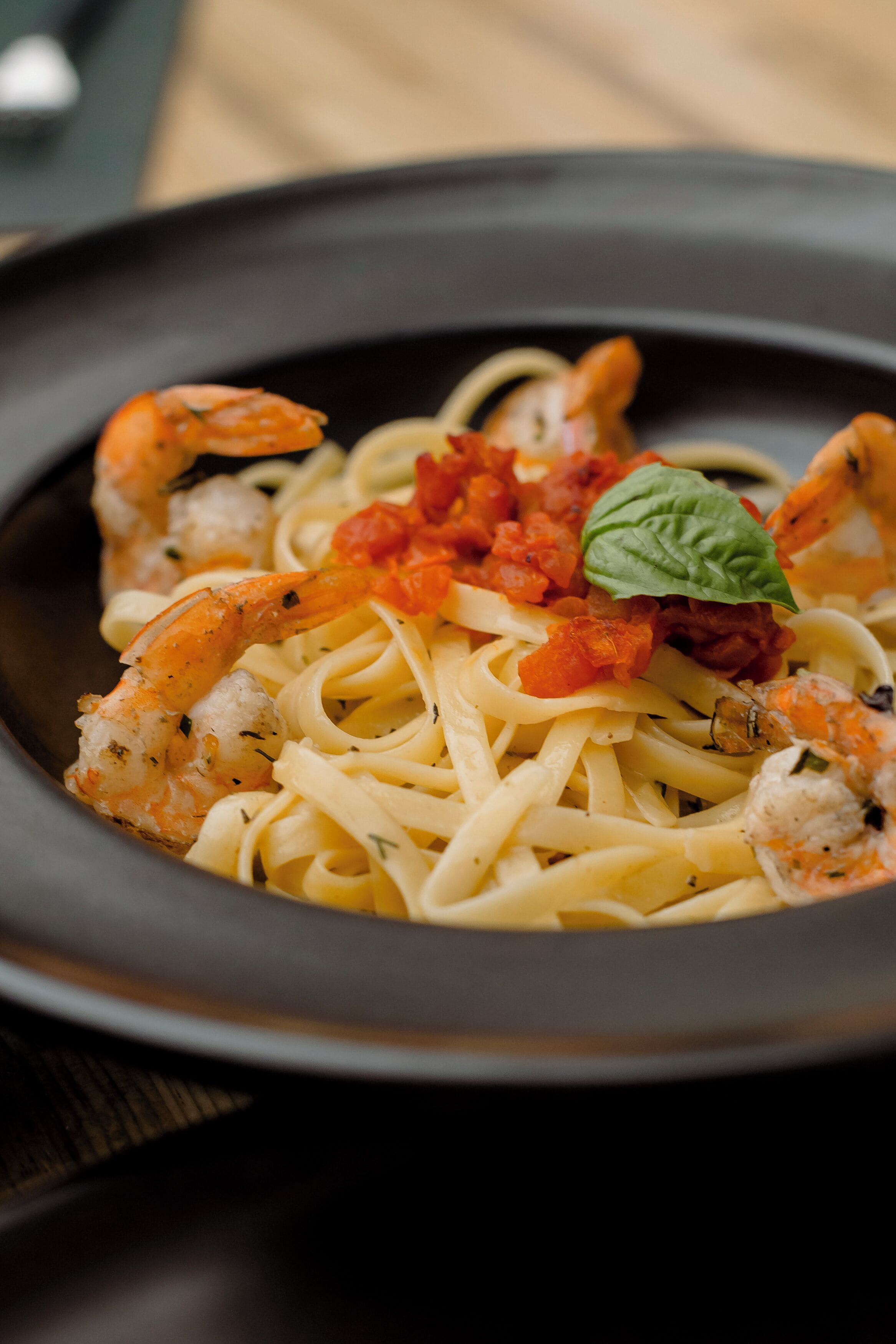 Un plato de pasta con camarones y salsa de tomate.