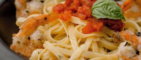 A bowl of pasta with shrimp and tomato sauce.