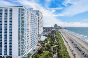 A high-rise hotel with multiple balconies, a pool area, and a beachfront view. - Bay View Resort (Myrtle Beach)