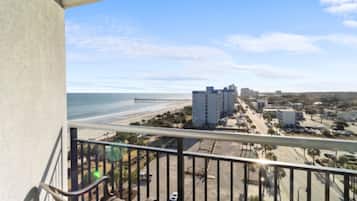 A balcony with a view of a beach and buildings.