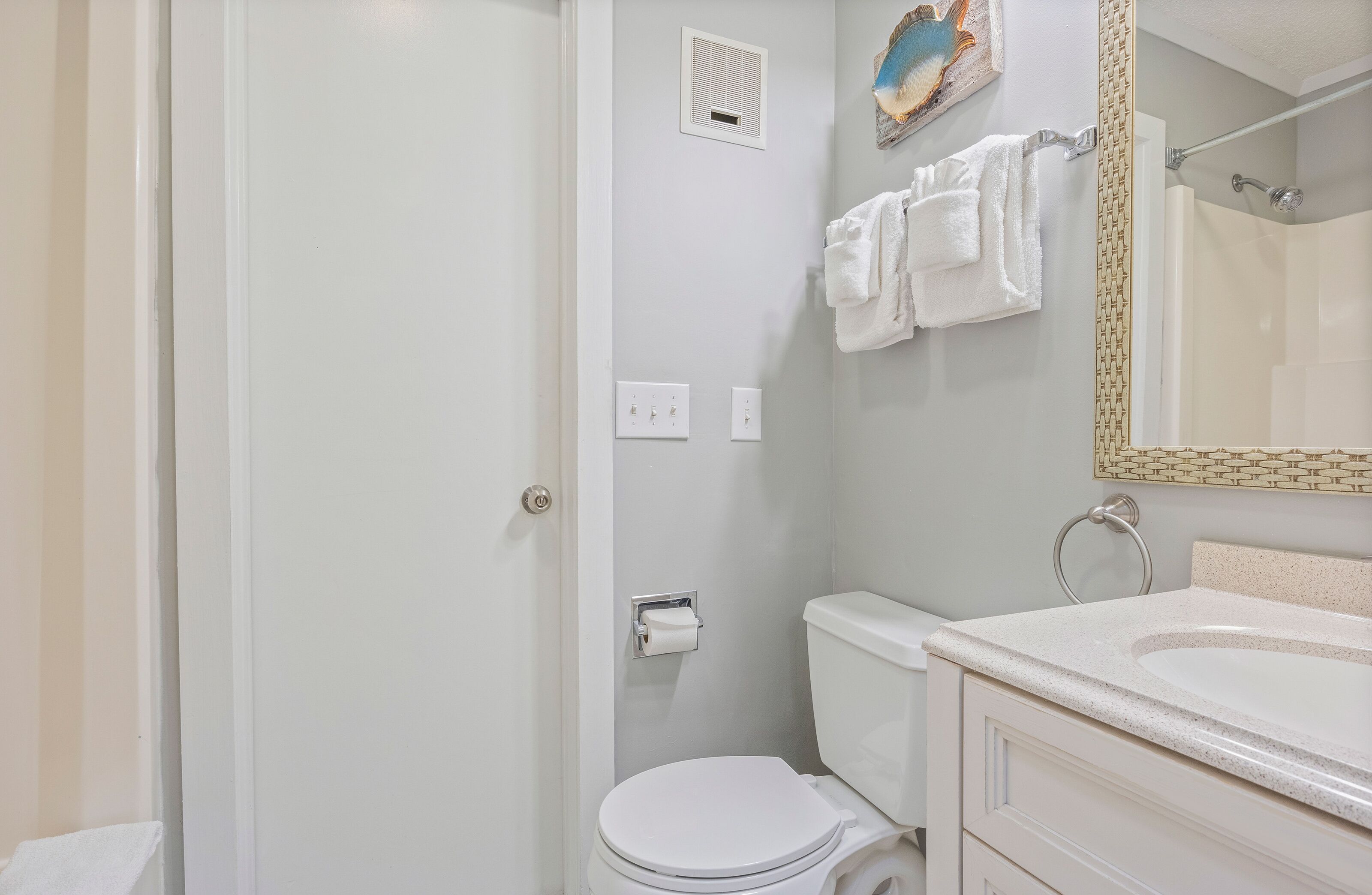 Een badkamer met toilet, wastafel en douche.