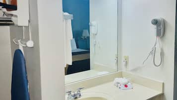 A bathroom with a sink, mirror, and hairdryer.