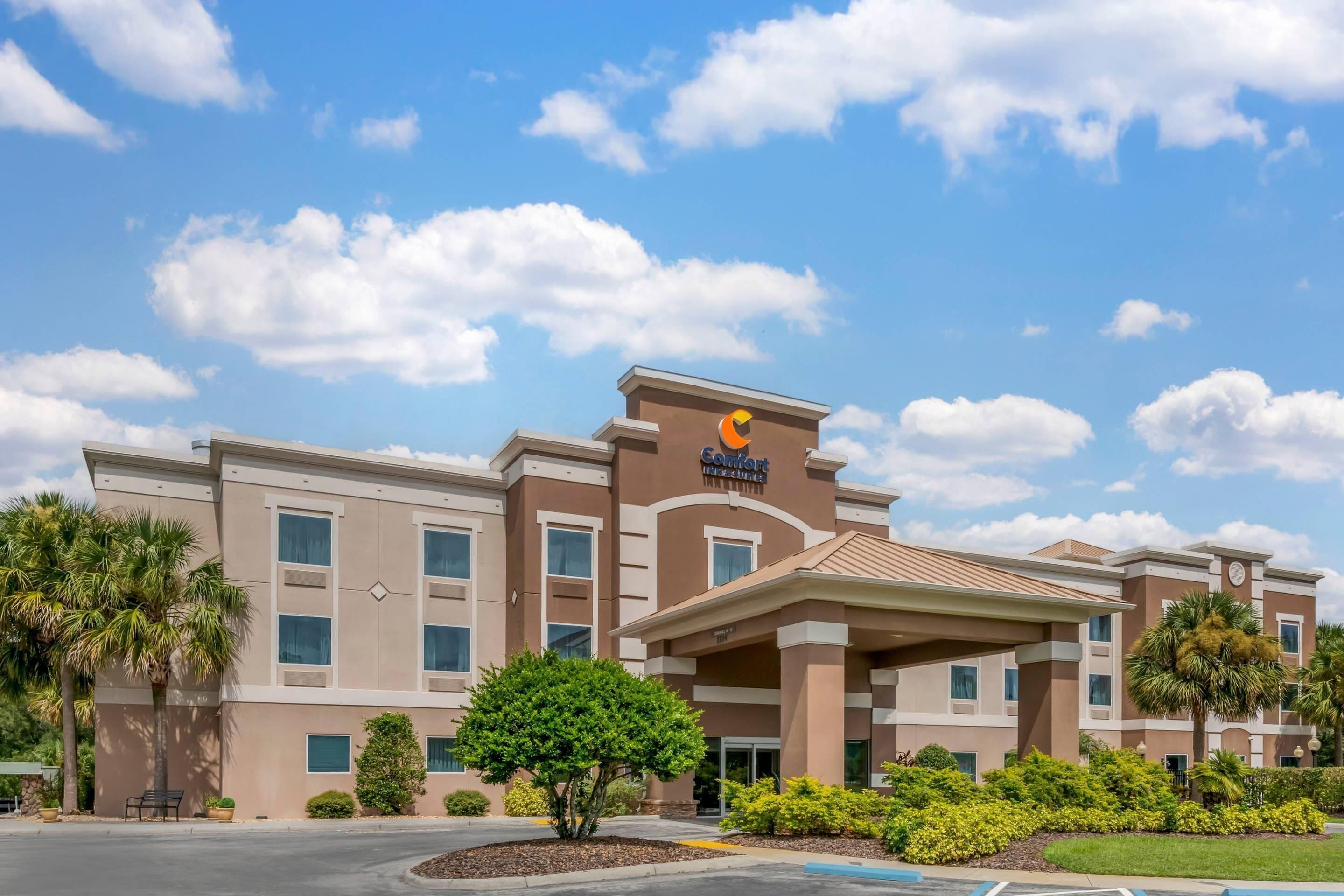 A hotel with a modern design, featuring a prominent sign and a covered entrance.