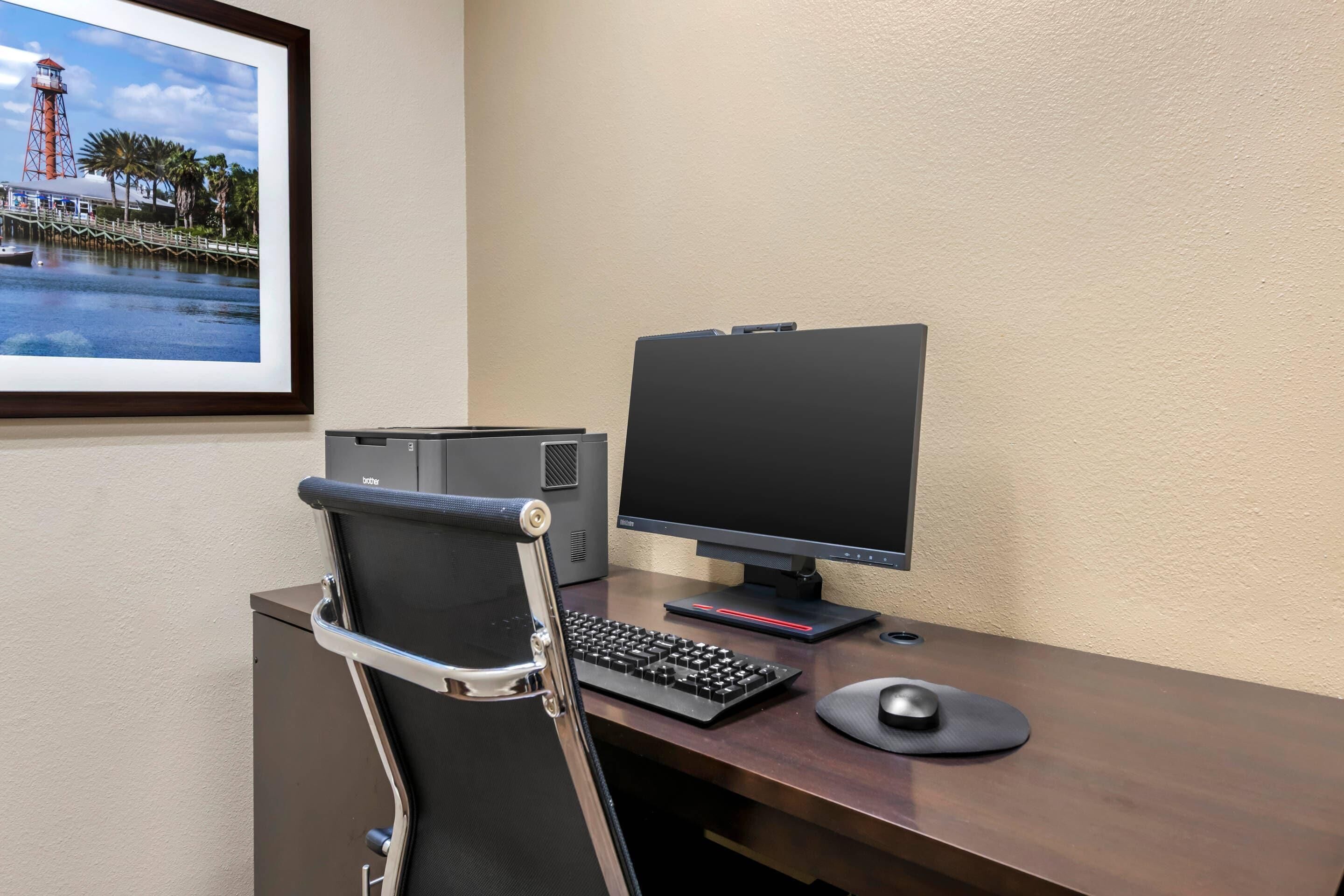 A desk with a computer setup, including a monitor, keyboard, and mouse.