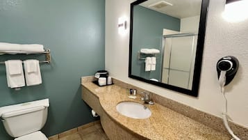A bathroom with a toilet, sink, and towel rack.