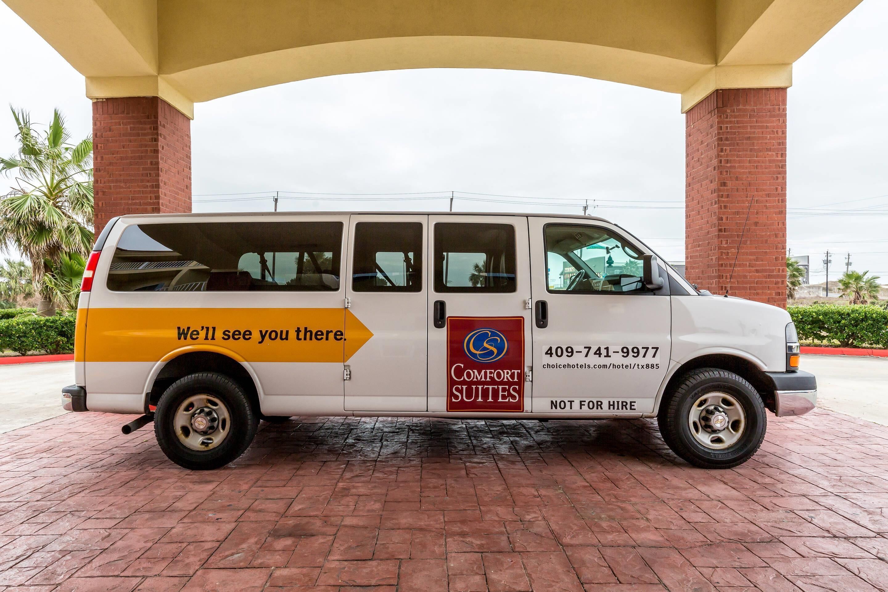 A white van with 'Comfort Suites' branding and a phone number for booking.