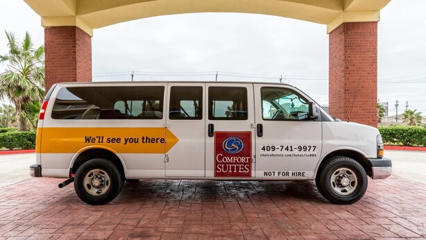 A white van with 'Comfort Suites' branding and a phone number for booking.