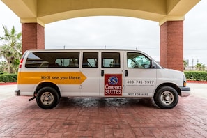A white van with 'Comfort Suites' branding and a phone number for booking.