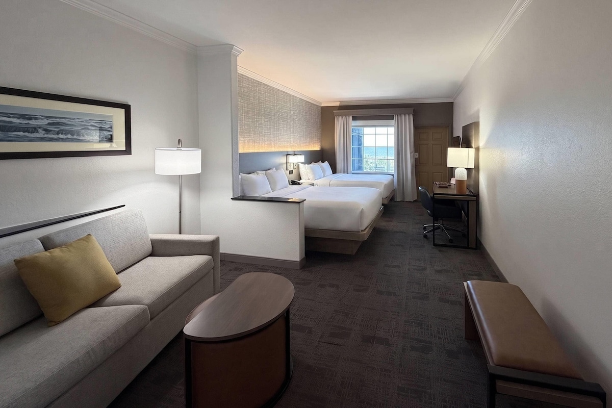 Ein Hotelzimmer mit einem Bett, einem Sofa, einem Schreibtisch und einem Sessel.