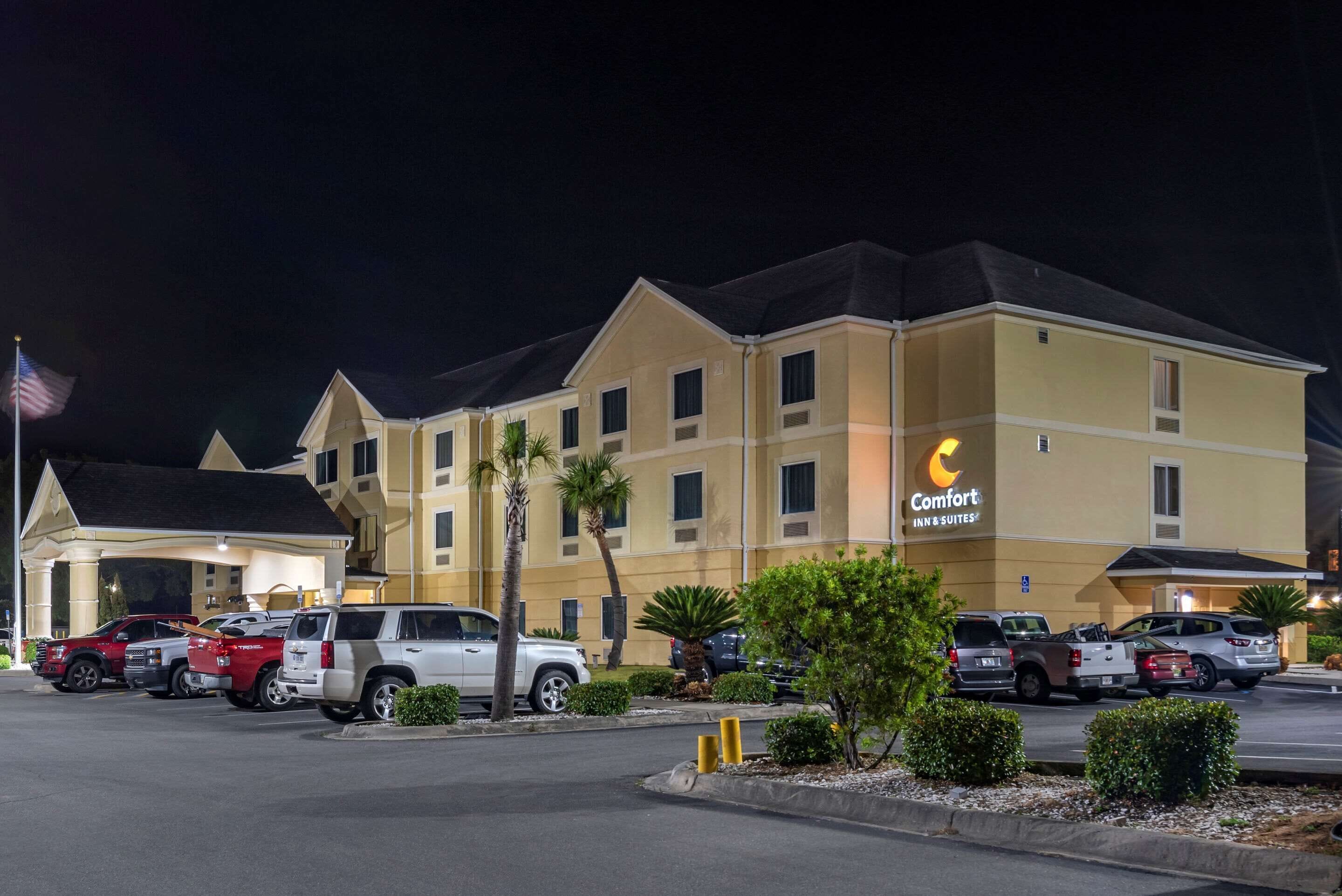A Comfort Inn & Suites hotel with a parking lot and several SUVs parked in front.
