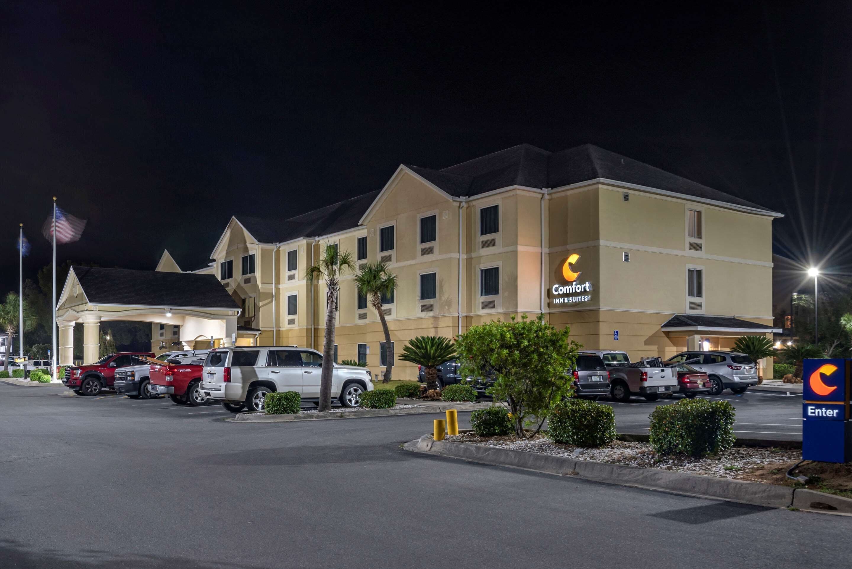 Un hôtel Comfort Inn & Suites doté d’un parking où sont garés plusieurs VUS à l’avant.