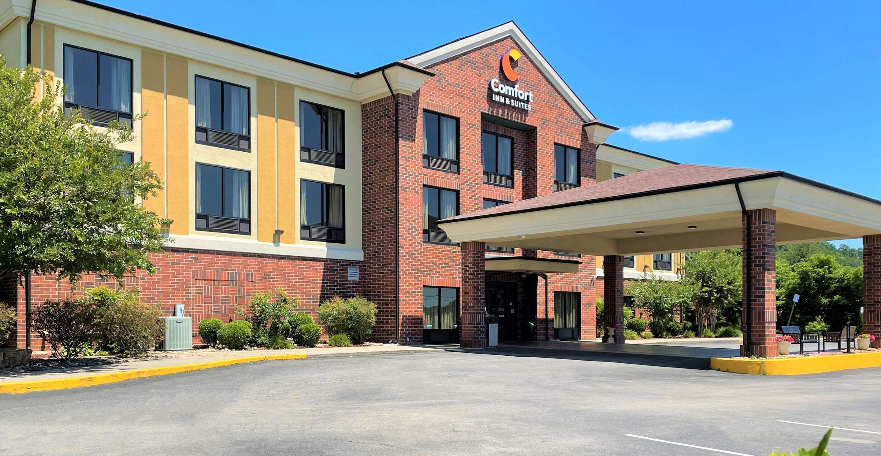 Ein Comfort Inn & Suites Hotel mit Backsteinfassade, überdachter Eingangsparte und Parkplatz.