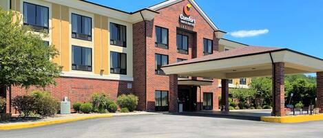 Ein Comfort Inn & Suites Hotel mit Backsteinfassade, überdachter Eingangsparte und Parkplatz.