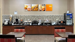 A restaurant with a counter, seating, and a tiled backsplash.