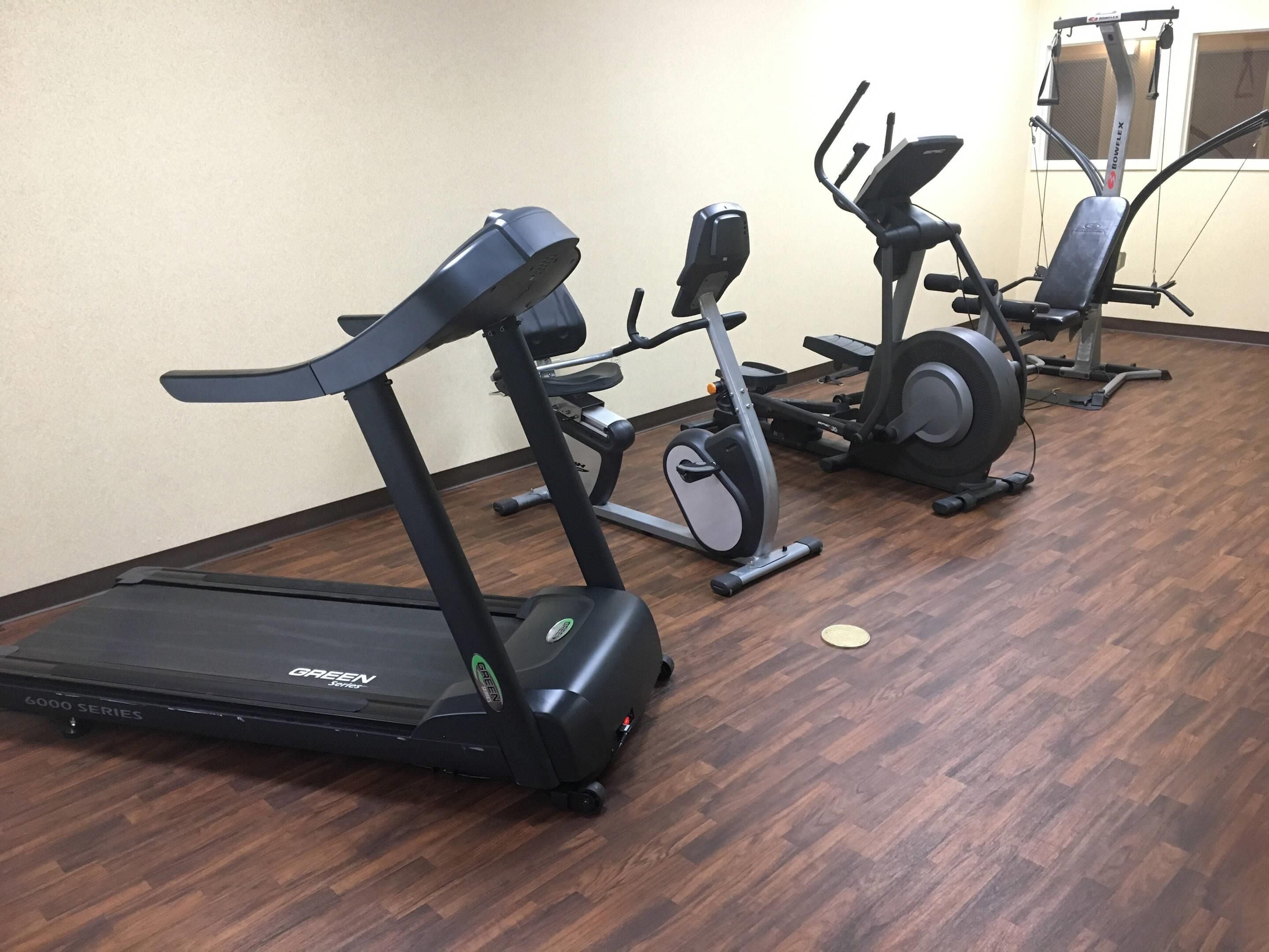 A gym with treadmills, an elliptical, and a stationary bike.