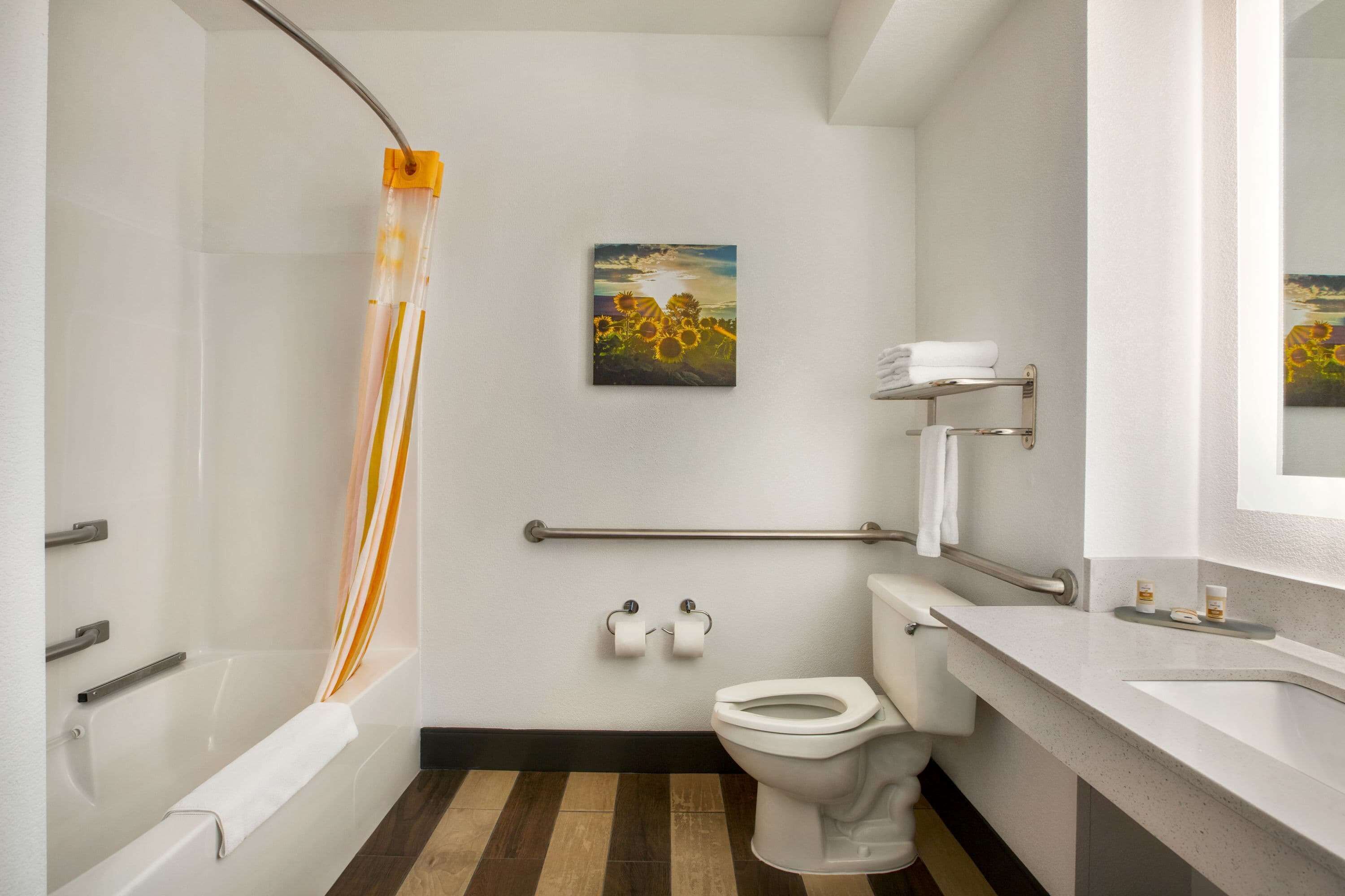 A modern bathroom with a bathtub, toilet, and shower.