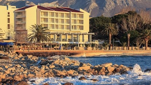 A hotel with multiple floors, balconies, and a view of the sea. - Hotel Princess (Bar)