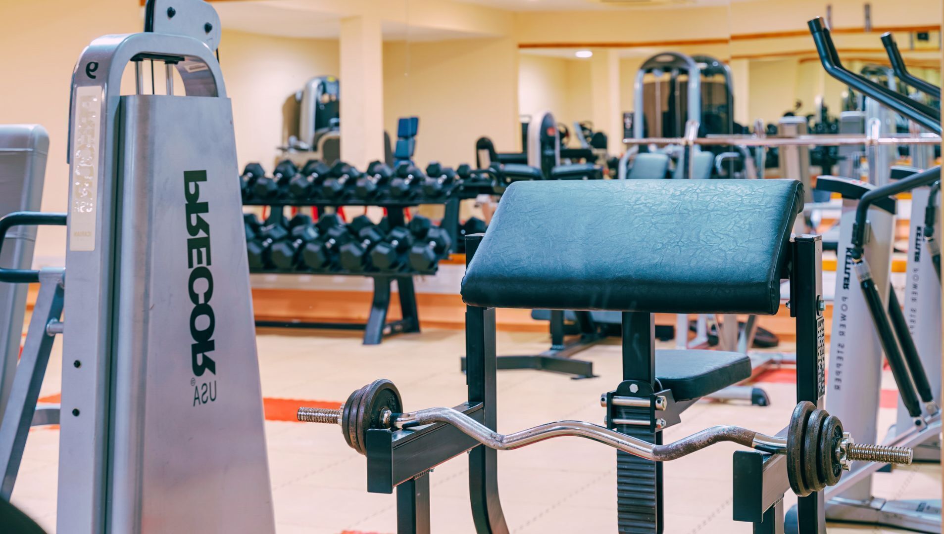 A gym with weightlifting equipment, including a bench and dumbbells.