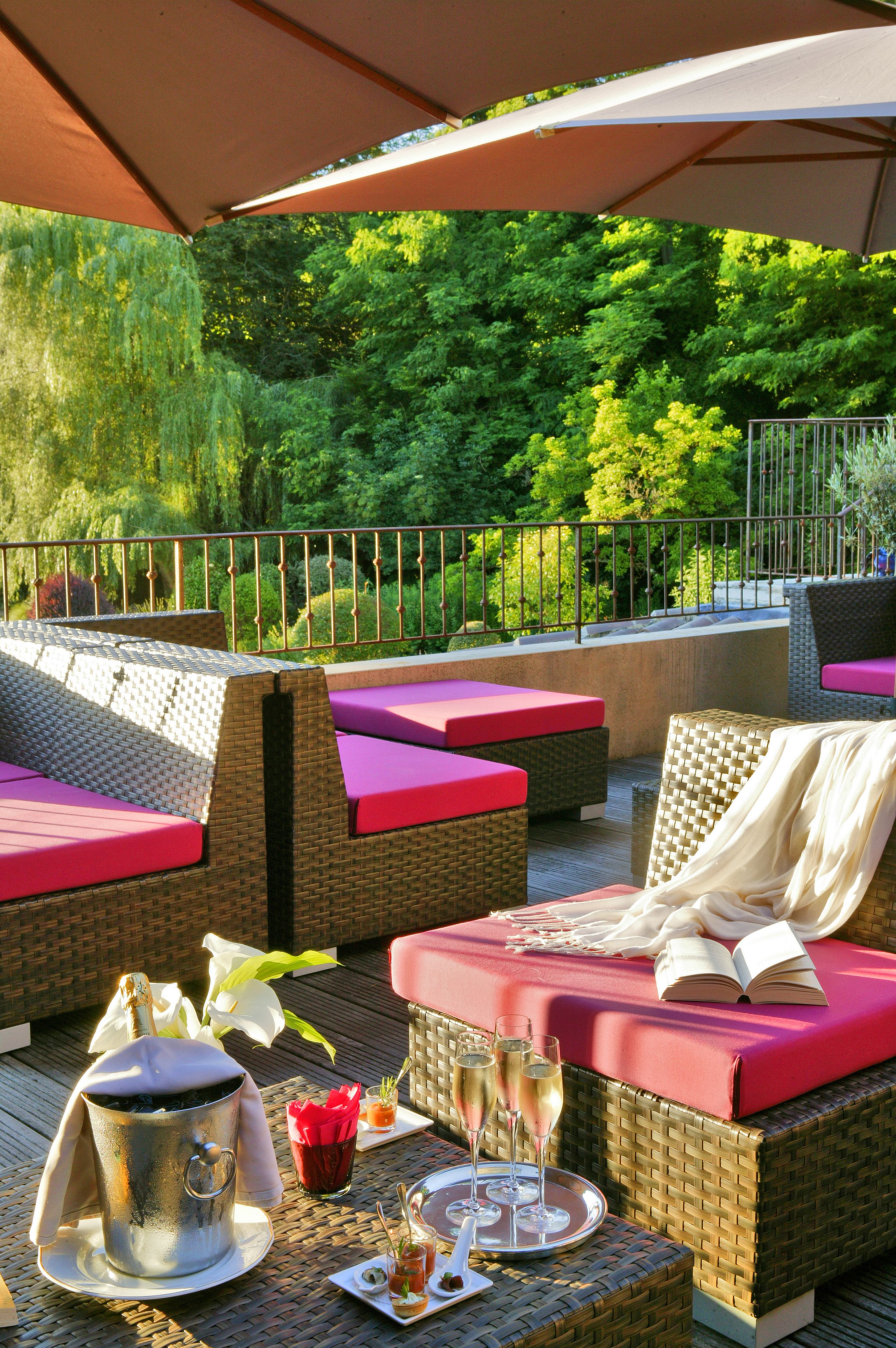 A terrace with wicker furniture, a metal bucket, and a tray with drinks.