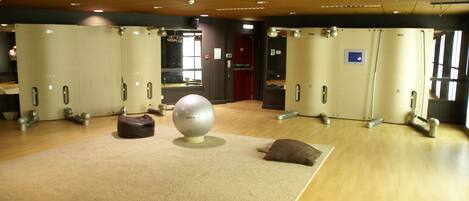 A room with exercise equipment, a large mirror, and a door with a sign.