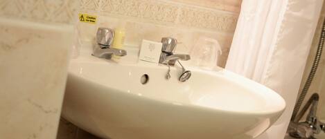 A bathroom with a white sink, a mirror, and a shower curtain.