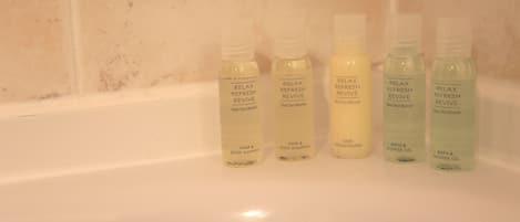 Cinco botellas de productos 'Relax Refresh Revive' sobre una superficie blanca.
