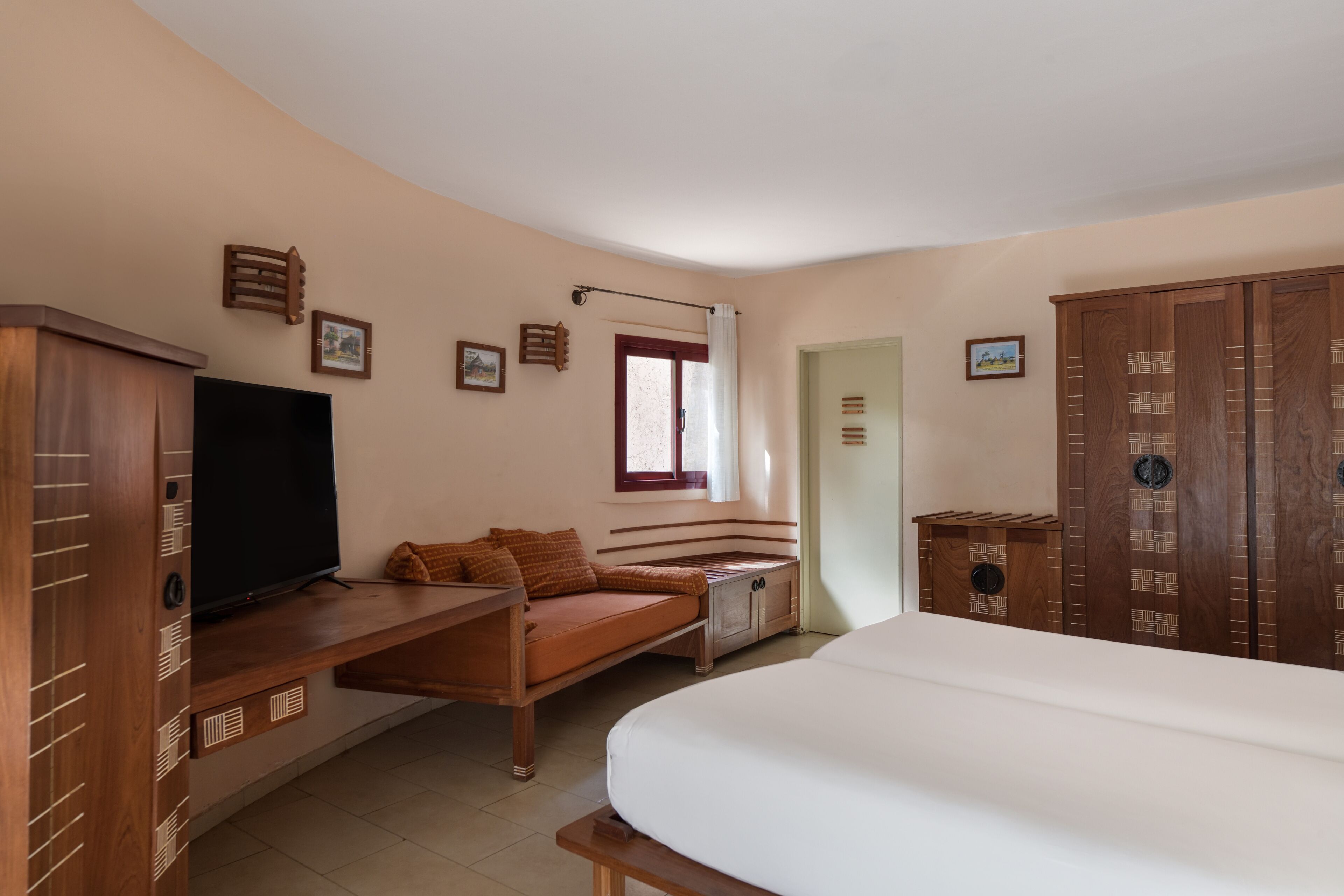 A bedroom with a bed, a TV, a sofa, and a wardrobe.