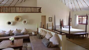 A room with a sofa, a bed, a wooden ceiling, and wall decorations.