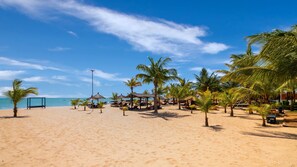On the beach, white sand, beach umbrellas, beach towels
