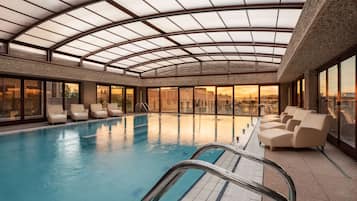 Una piscina cubierta, una piscina al aire libre, tumbonas