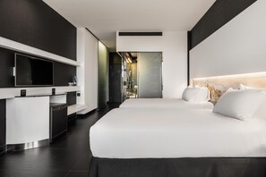 A modern hotel room with a large bed, a small desk, and a walk-in closet. - Hilton Madrid Airport (Madrid)