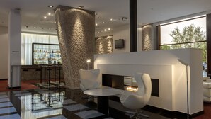 Un espace bar moderne doté d’une cheminée, de sièges et d’un comptoir.