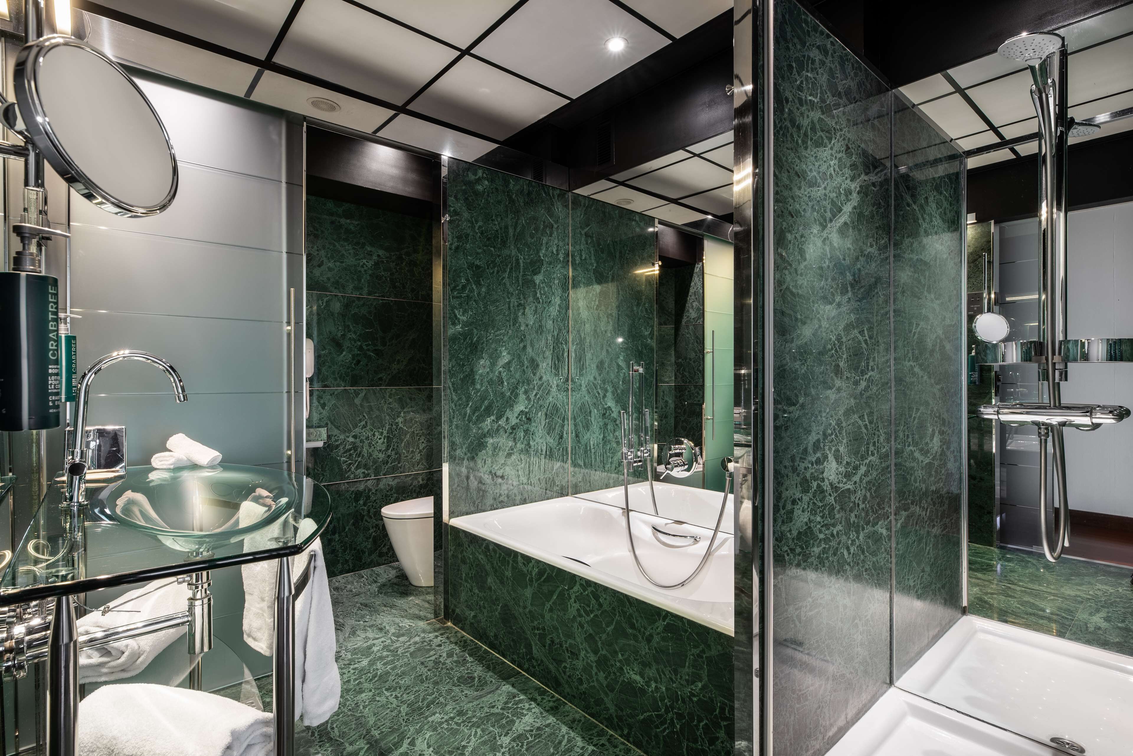 Une salle de bain moderne avec une douche à parois de verre, un lavabo en verre et des toilettes.