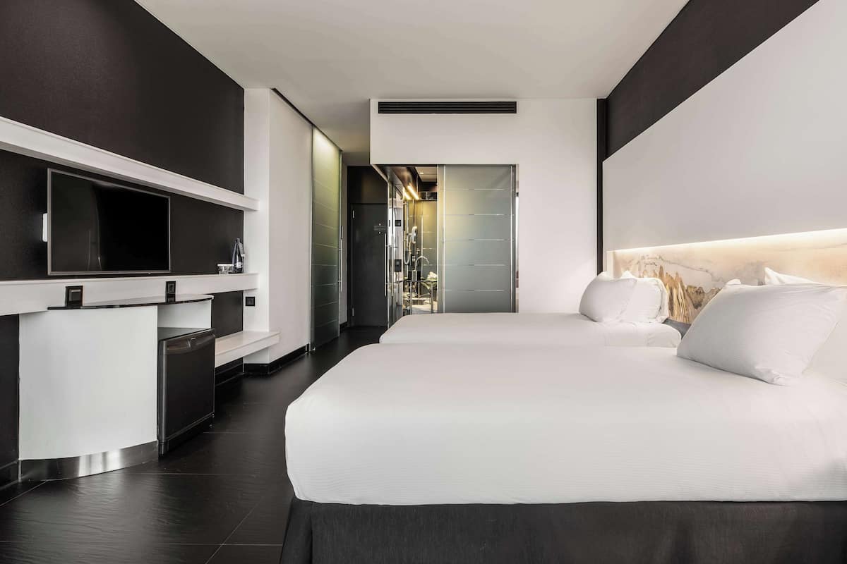 Een moderne hotelkamer met een groot bed, een bureau met een flatscreen televisie en een inloopkast.