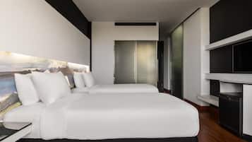Una camera d'albergo moderna con un letto grande, una TV a schermo piatto e un quadro appeso al muro.