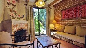 Ein gemütliches Wohnzimmer mit Kamin, einer Couch, einem Tisch und einer Wand mit Muster.
