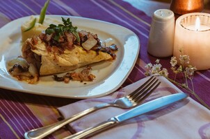 Un plato de comida con una vela y saleros y pimenteros sobre una mesa.