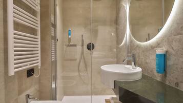 Une salle de bain moderne avec une douche à l’italienne, deux vasques et un grand miroir.