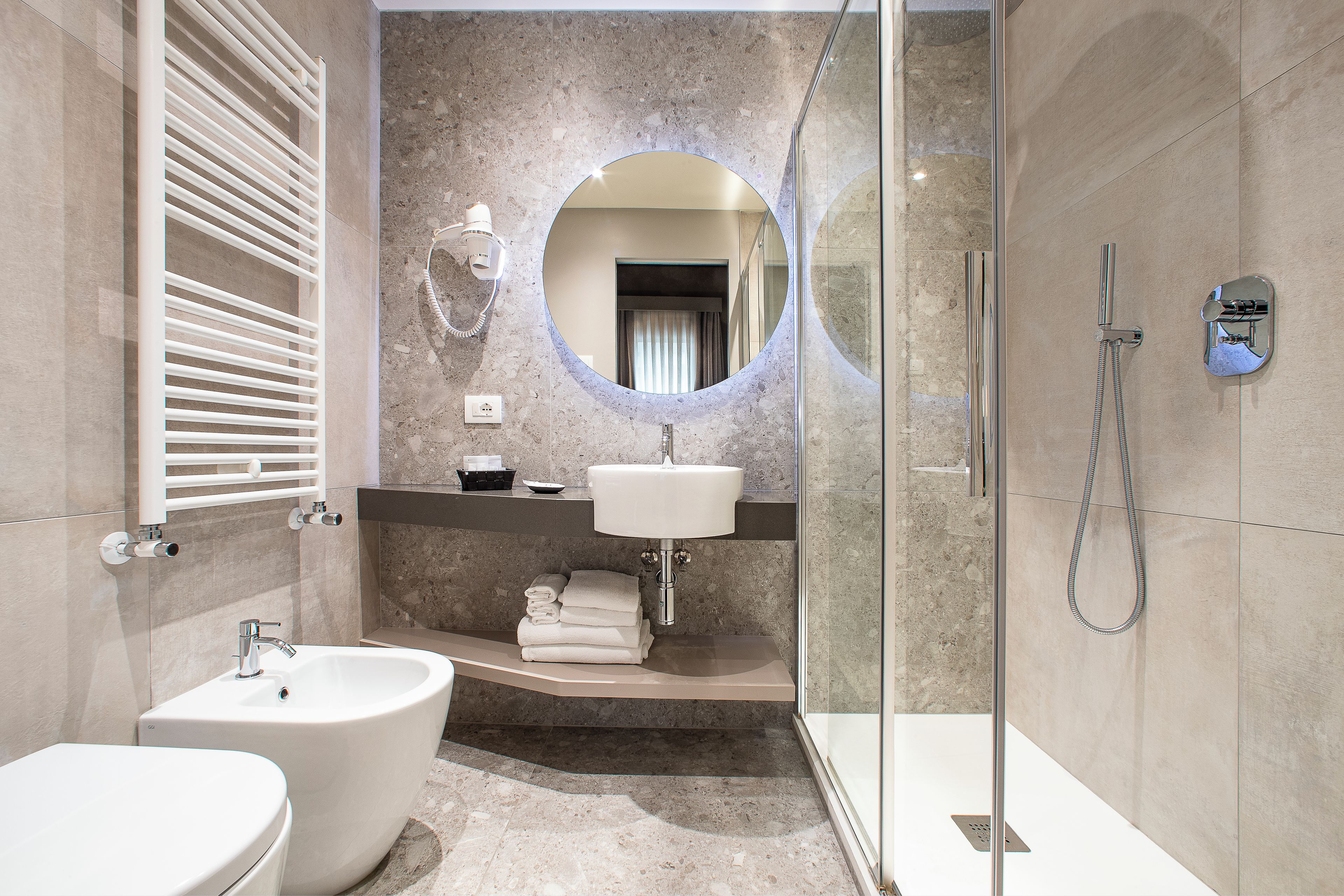 A modern bathroom with a freestanding bathtub, a sink, and a glass-enclosed shower area.