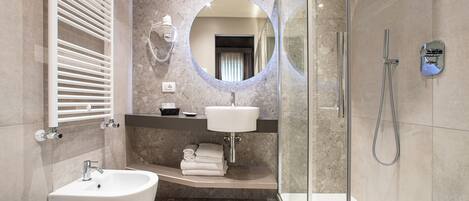 A modern bathroom with a freestanding bathtub, a sink, and a glass-enclosed shower area.
