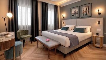 Ein modernes Hotelzimmer mit einem großen Bett, einem Schreibtisch mit Lampe, einem Sessel und einem kleinen Tisch.
